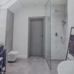 Nowoczesna łazienka z kabiną prysznicową typu walk-in, wiszącą toaletą i szarymi płytkami podłogowymi.