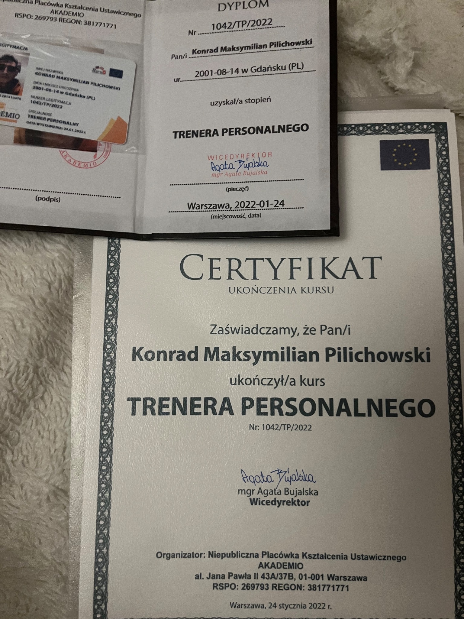 Dyplom i certyfikat ukończenia kursu trenera personalnego Konrad Maksymilian Pilichowski, numer dyplomu 1042/TP/2022, podpisane przez wicedyrektora Agatę Bujalską.