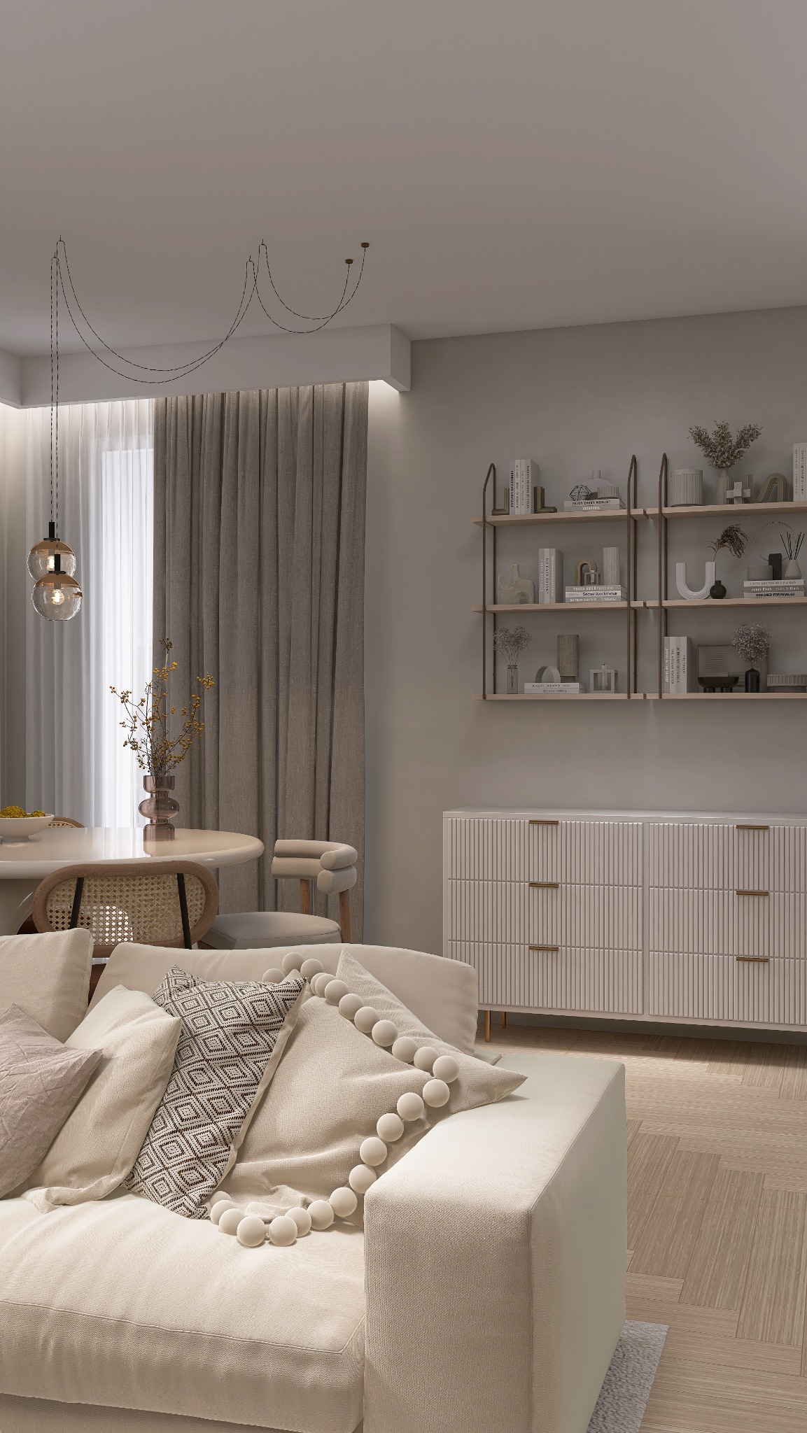 Jasne wnętrze salonu: kremowa sofa z poduszkami, okrągły stół z rattanowymi krzesłami, komoda z półkami na ścianie. Minimalistyczny design, ciepłe oświetlenie.