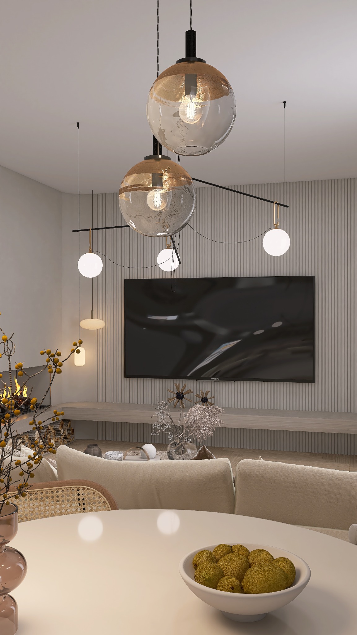 Nowoczesny salon z kominkiem i designerskim oświetleniem. Okrągły stół z owocami na pierwszym planie, w tle telewizor i dekoracje. Stonowana kolorystyka.