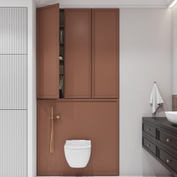 MOIA studio - Nowoczesna łazienka w odcieniach brązu i bieli, z wiszącą toaletą, złotą armaturą i szafką z otwartymi drzwiczkami, ukazującymi półki z akcesoriami.