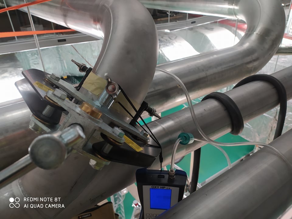 Instalacja rur ze stali nierdzewnej z zamontowanym czujnikiem pomiarowym OXY HP 2.0, widoczne mocowania i elementy instalacyjne. Ujęcie od dołu.