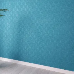 Turkusowa ściana z delikatnym wzorem, biała listwa przypodłogowa i drewnopodobna podłoga, uzupełnione przez wysoką roślinę w białej donicy.