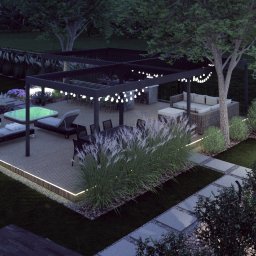 Pracownia Zieleni Konrad Zając - Wieczorna wizualizacja ogrodu z jacuzzi, leżakami, pergolą oświetloną girlandami, stołem jadalnym i dekoracyjnymi trawami. Oświetlenie punktowe podkreśla roślinność.