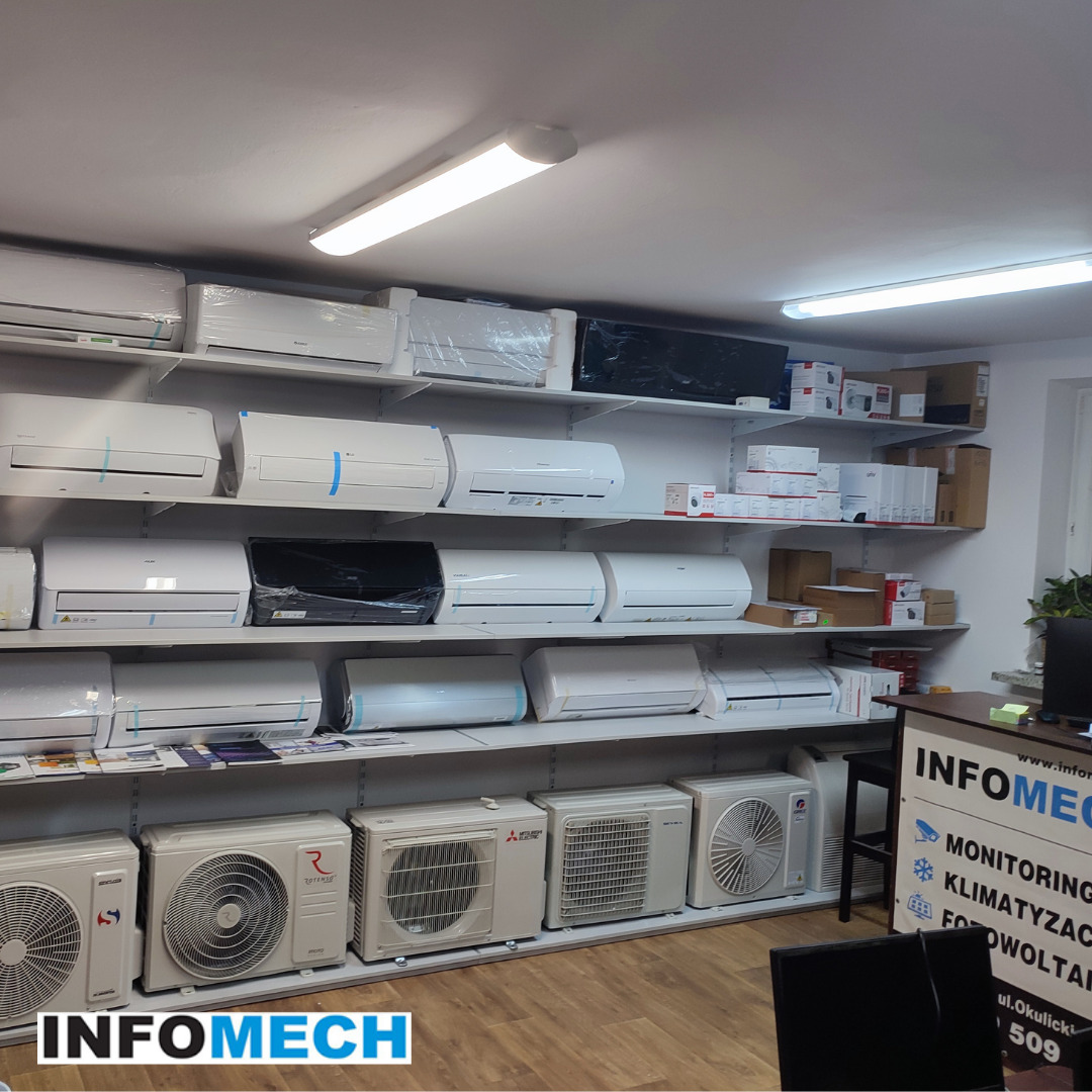 Sklep stacjonarny z klimatyzacją: ekspozycja różnych modeli klimatyzatorów na półkach, w tym jednostki wewnętrzne i zewnętrzne, z logo firmy Infomech widocznym w dolnym rogu zdjęcia.