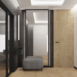 Cognac Architects - Nowoczesny przedpokój z drewnianą podłogą ułożoną w jodełkę, szarymi ścianami z oświetleniem LED, lustrem w czarnej ramie i pufami w kolorze szarym.