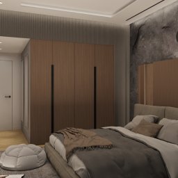 Cognac Architects - Nowoczesna sypialnia z łóżkiem, drewnianą zabudową za wezgłowiem, szarą ścianą z efektem kamienia, okrągłymi lampami wiszącymi i pufą na dywanie.