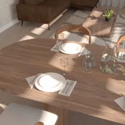 Jadalnia z drewnianym stołem, nakrytym białymi talerzami i szklankami z wodą i cytryną, w tle brązowa sofa i beżowy dywan