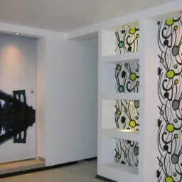 Wykończone wnętrze z fototapetą przedstawiającą most i panoramę miasta oraz ścianą z wnękami i dekoracyjnym wzorem.