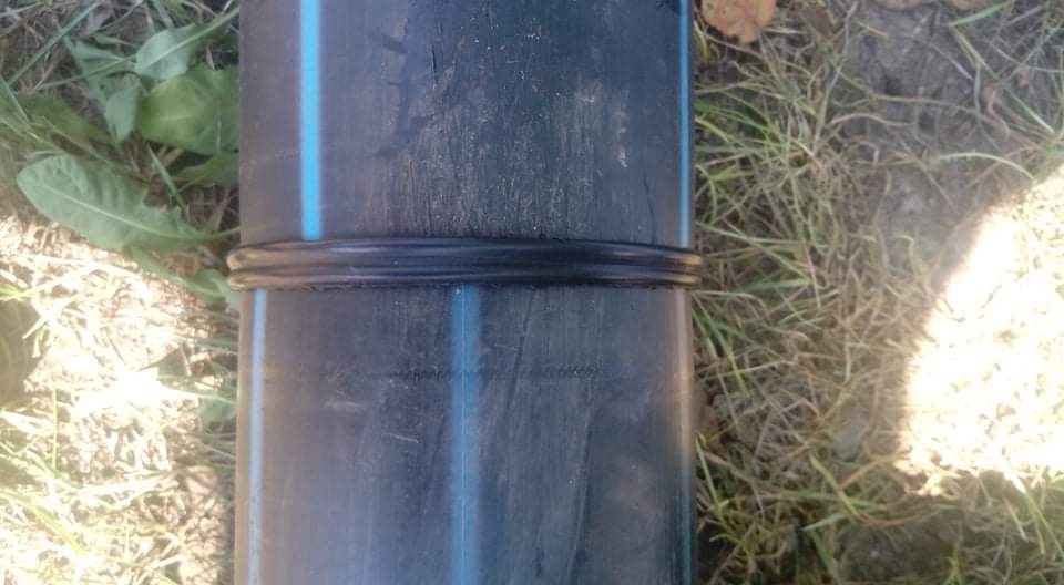 Połączenie rury wodociągowej z uszczelką na tle trawy.