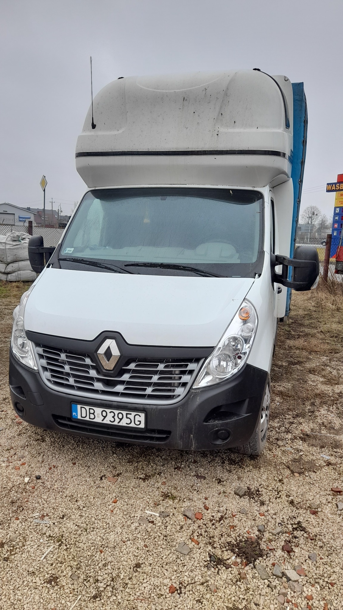 Biały bus Renault Master z zabudową kontenerową na parkingu, widoczny numer rejestracyjny DB 9395G.