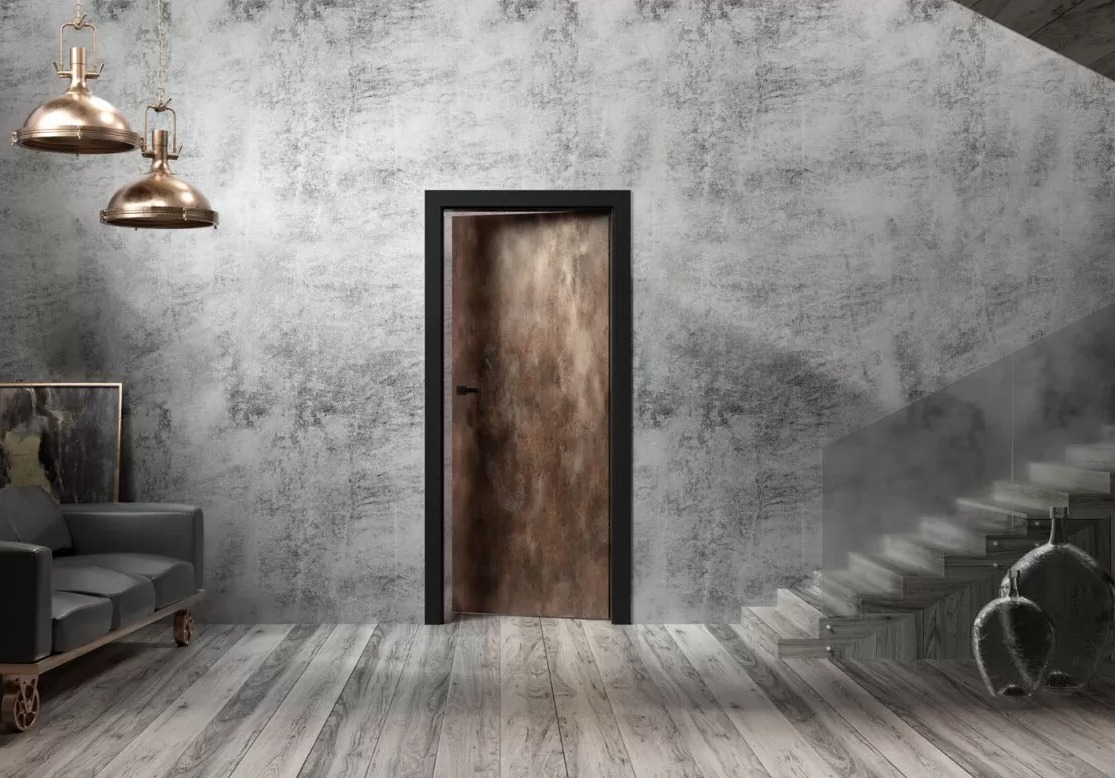 Wnętrze z drewnianą podłogą, szarą ścianą o fakturze betonu, brązowymi lampami wiszącymi, ciemną sofą i drewnianymi schodami ze szklaną balustradą, z centralnie umieszczonymi drzwiami w ciemnej...