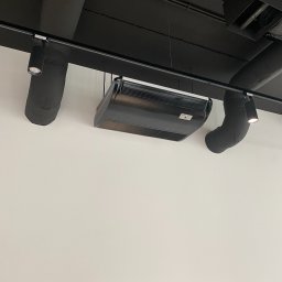 Firma Handlowo Usługowa IGLOO-BIS Paweł Piasny - Czarna klimatyzacja kasetonowa zamontowana pod czarnym sufitem z widocznymi rurami wentylacyjnymi i oświetleniem punktowym.