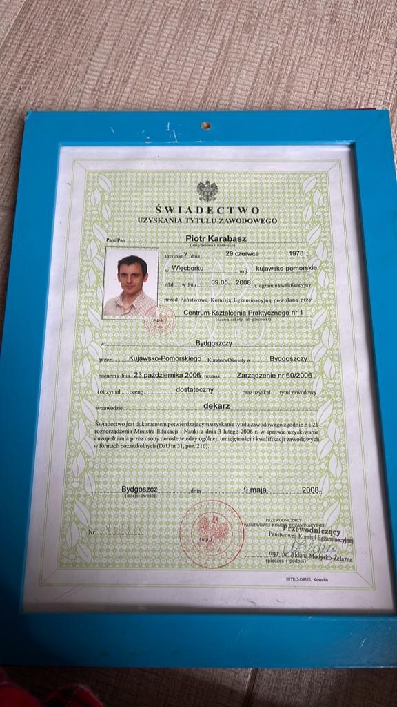 Skan świadectwa uzyskania tytułu zawodowego dekarza, oprawiony w niebieską ramkę, z datą wystawienia 9 maja 2008 roku w Bydgoszczy, zawierający zdjęcie Piotra Karabasza.