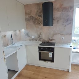 Andrii Kulchenko - Nowoczesna kuchnia z białymi szafkami, marmurowym blatem i okładziną ścienną o wzorze marmuru, czarnym okapem cylindrycznym oraz drewnianą podłogą z paneli.