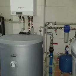 Kotłownia z zamontowanym kotłem Viessmann, zasobnikiem Galmet, grupą pompową i filtrem wody, widoczne rury i zawory