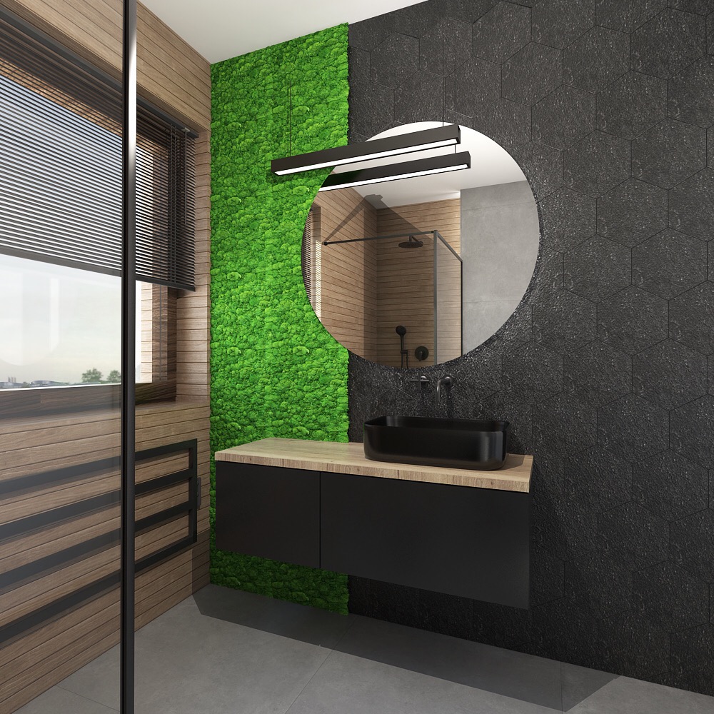 Nowoczesna łazienka z czarną umywalką nablatową, okrągłym lustrem i ścianą z mchu, oświetlona podłużną lampą nad lustrem, z heksagonalnymi czarnymi płytkami na ścianie i drewnianymi panelami po...