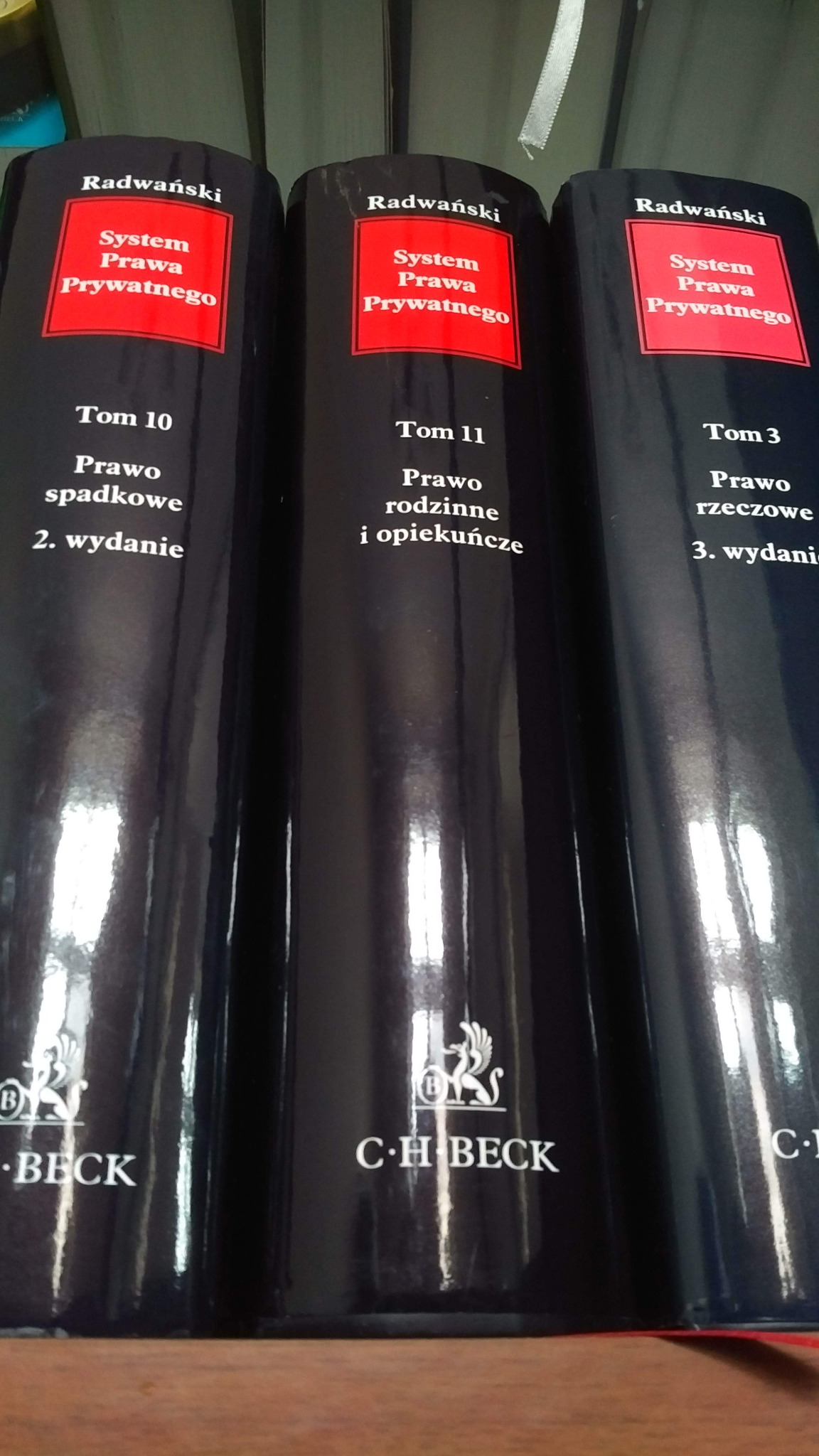 Grzbiety trzech tomów Systemu Prawa Prywatnego Radwańskiego, wydawnictwa C.H. Beck: Prawo spadkowe (Tom 10, wydanie 2), Prawo rodzinne i opiekuńcze (Tom 11) oraz Prawo rzeczowe (Tom 3, wydanie 3).