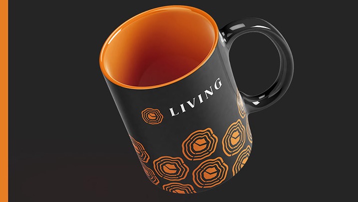 Czarny kubek z pomarańczowym wnętrzem i wzorem przypominającym przekrój pnia drzewa oraz napisem 'LIVING' na ciemnym tle.