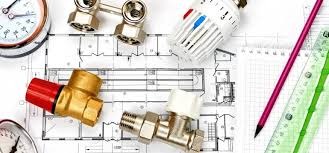 Plan domu z naniesionymi elementami instalacji, widoczne zawory, termostat, manometry oraz przybory kreślarskie.