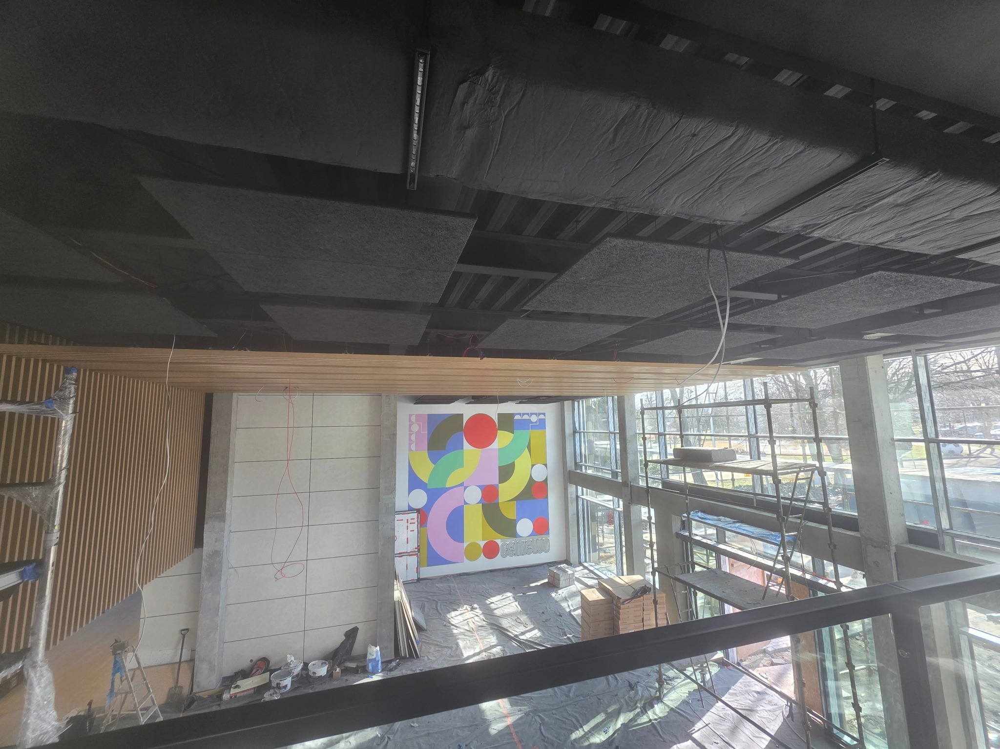 Montaż sufitu akustycznego w Połczynie. Widok z góry na wnętrze w trakcie prac wykończeniowych, z widocznymi elementami konstrukcyjnymi i materiałami budowlanymi.