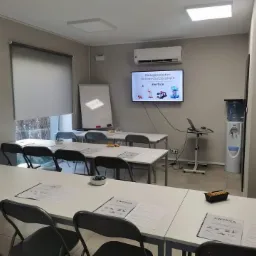 Sala szkoleniowa w Gliwicach, przygotowana do kursu obsługi podestów ruchomych przejezdnych, z laptopem, ekranem wyświetlającym prezentację i rozłożonymi materiałami dla uczestników.