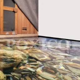 Iluzjonistyczna posadzka z efektem 3D imitująca dno strumienia z kamieniami, przylegająca do ściany z motywem wodospadu i drewnianej konstrukcji.