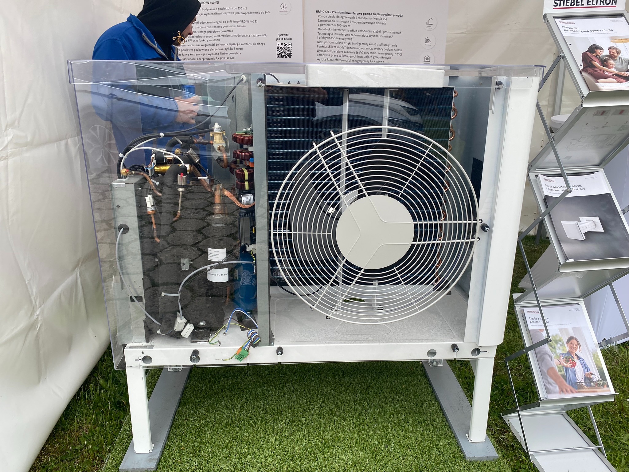 Wnętrze pompy ciepła powietrze-woda marki Stiebel Eltron, widoczne elementy instalacji w Katowicach, pracownik w niebieskim ubraniu podczas montażu.