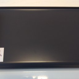 Ideal Rafał Dyro - Szary aluminiowy parapet z zaokrąglonym brzegiem i naklejką producenta Ideal, model Softline RAL 7016, widoczny na jasnym tle.