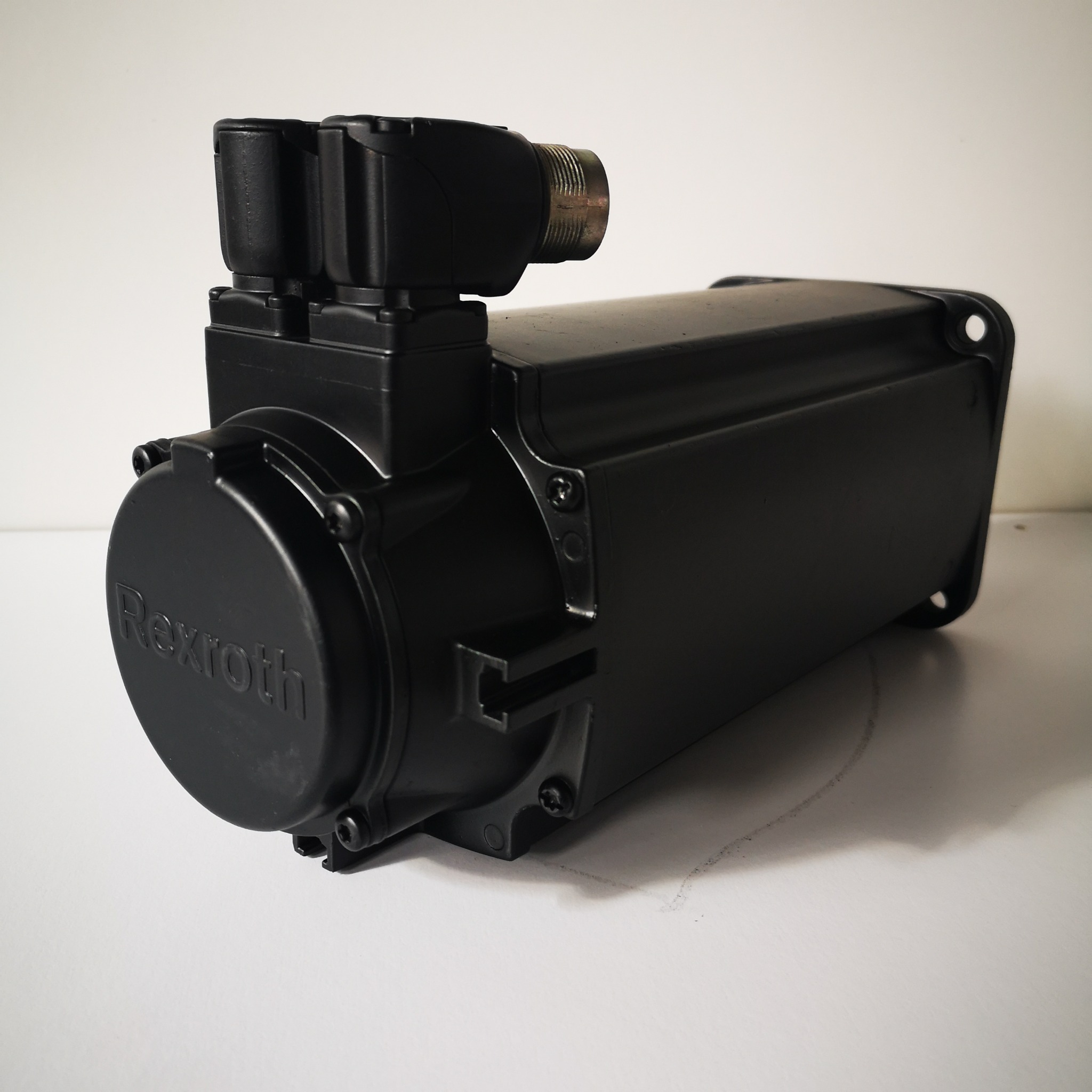 Czarny silnik elektryczny Rexroth z widocznymi złączami, umieszczony na białym tle.