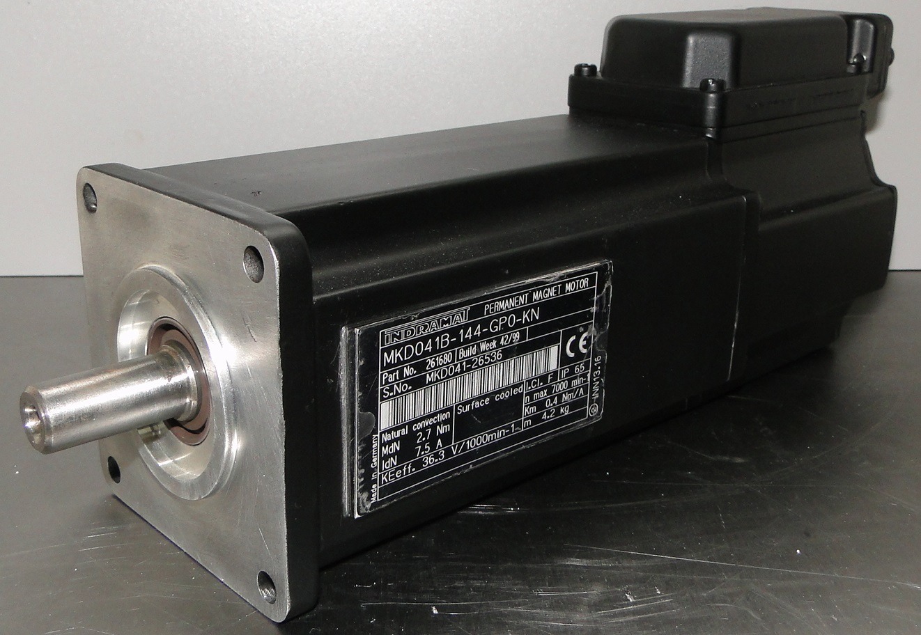 Czarny silnik elektryczny Indramat MKD041B-144-GPO-KN z aluminiowym kołnierzem mocującym i stalowym wałem, widoczna tabliczka znamionowa z danymi technicznymi.