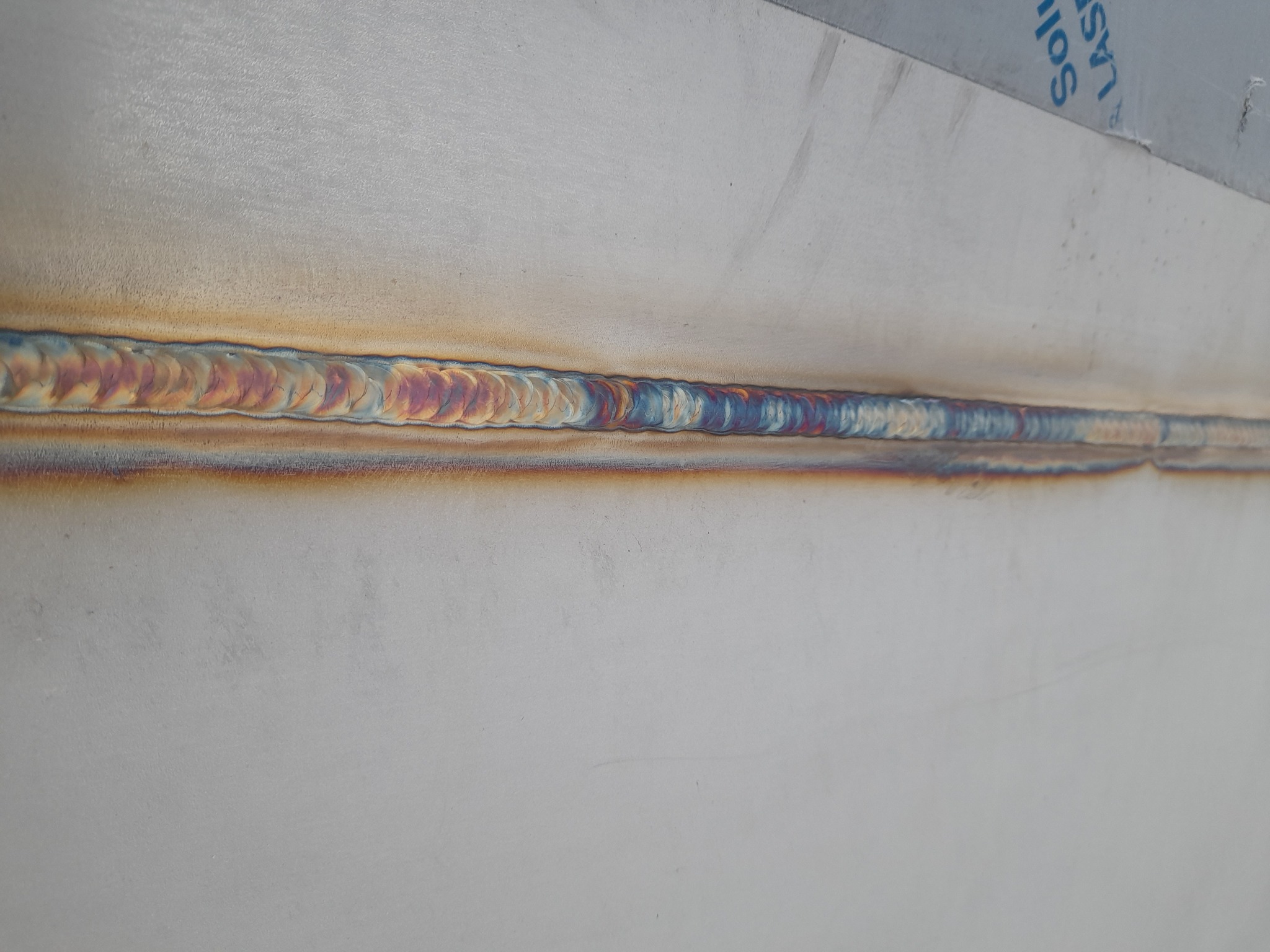 Spoina spawalnicza TIG na stali nierdzewnej, widoczne charakterystyczne tęczowe przebarwienia.