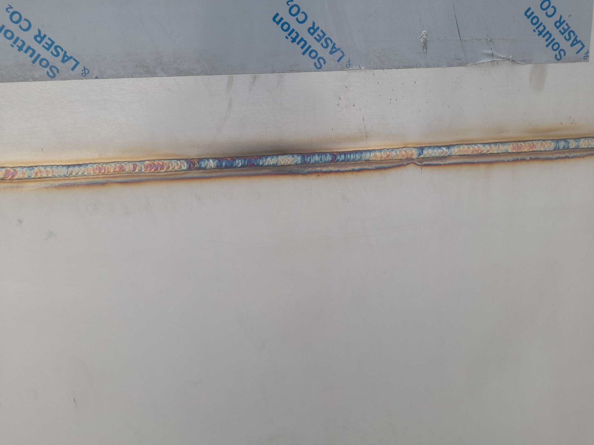 Spoina na metalowej powierzchni z widocznymi tęczowymi przebarwieniami termicznymi, wykonana metodą LASER CO2.