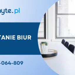 Jasne biuro z długim białym stołem konferencyjnym, czarnymi krzesłami, rośliną doniczkową na stole i przy oknie oraz wazonem z kredkami, widok na okno z ceglanym budynkiem w tle.