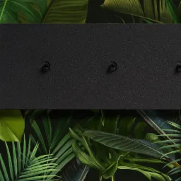 Czarna, prostokątna listwa oświetleniowa z trzema punktami świetlnymi na tle ściany z motywem tropikalnych liści.