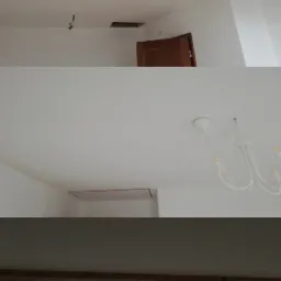 Wnętrze z trzema różnymi ujęciami sufitu po remoncie: widoczne drewniane belki, dwa okna dachowe, otwór w suficie oraz biały żyrandol.