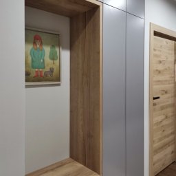 OLDI DESIGN SPÓŁKA Z OGRANICZONĄ ODPOWIEDZIALNOŚCIĄ - Szara szafa na wymiar z drewnianym regałem i obrazkiem dziewczynki z psem, drewniane drzwi w tle