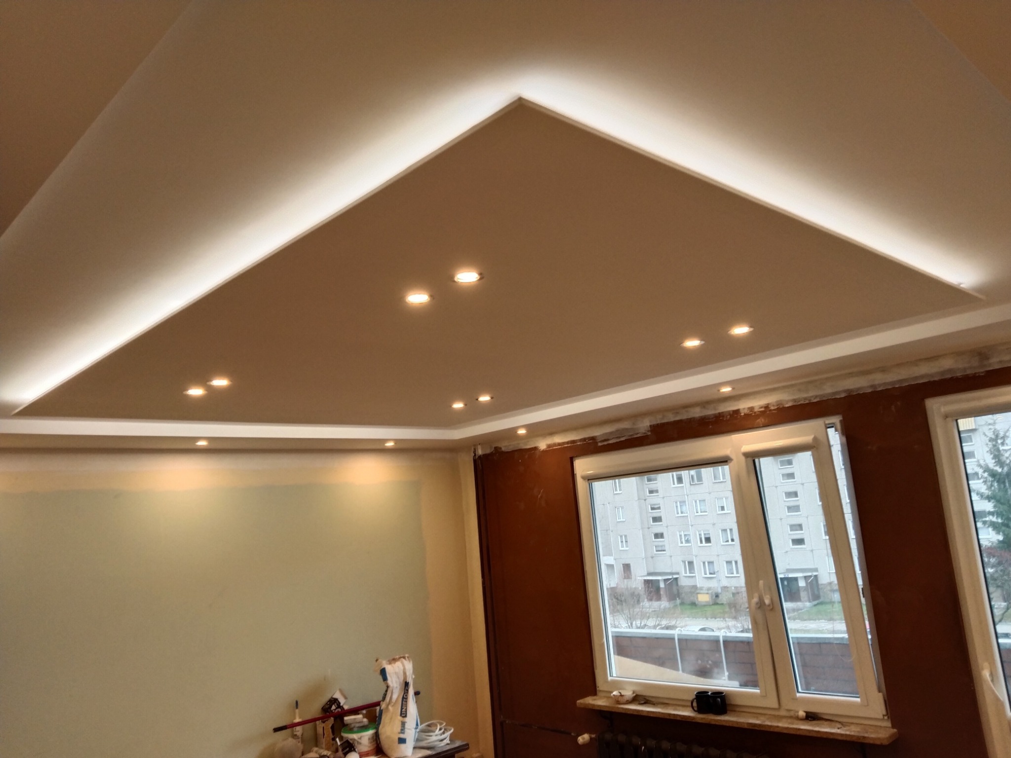 Wykończony sufit podwieszany z oświetleniem punktowym i listwami LED w Borowie, widoczne przygotowania do dalszych prac wykończeniowych na ścianach.