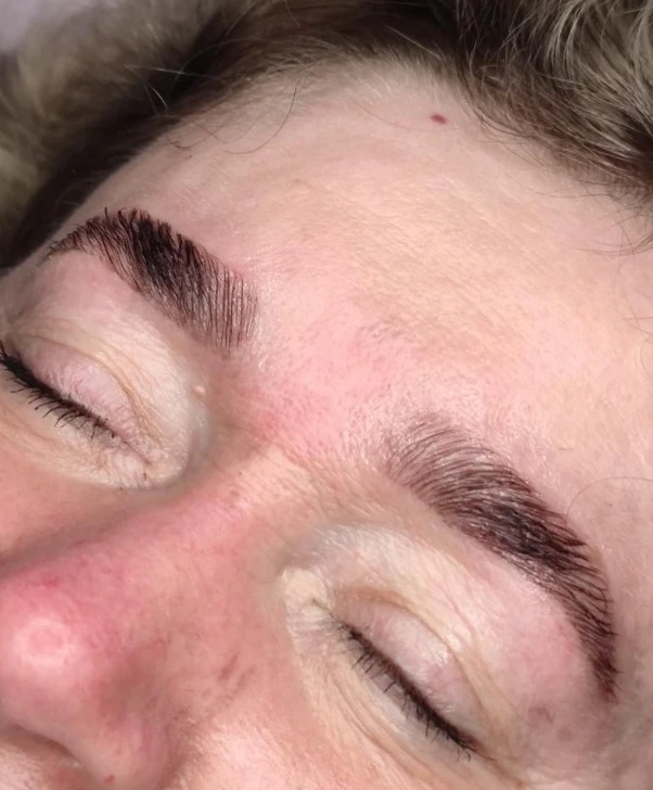 Makro zbliżenie na brwi po zabiegu laminacji, widoczne pojedyncze włoski i subtelny połysk.