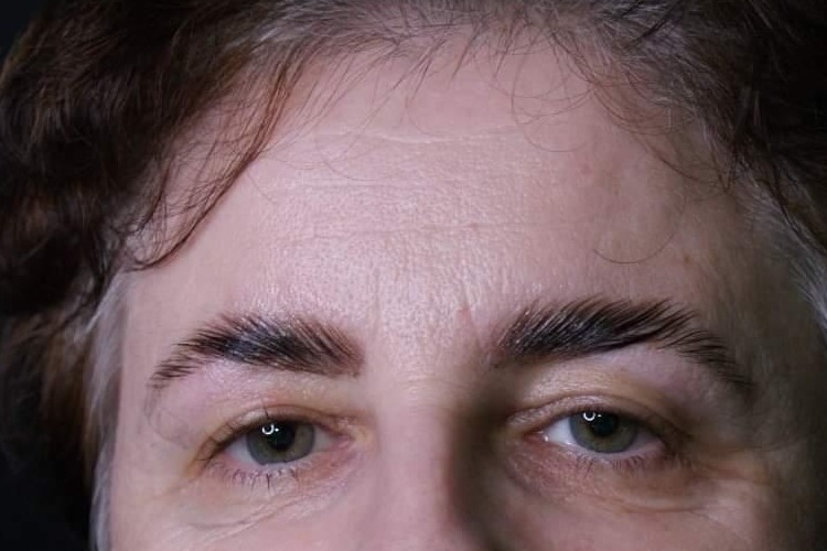 Zbliżenie na brwi po zabiegu laminacji, ukazujące ich uniesienie i błyszczące wykończenie.