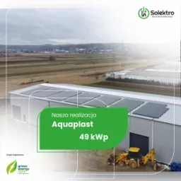 Widok z góry na budynek przemysłowy Aquaplast z zainstalowanymi panelami słonecznymi o mocy 49 kW, na tle krajobrazu wiejskiego i logo Solektro w górnym rogu.