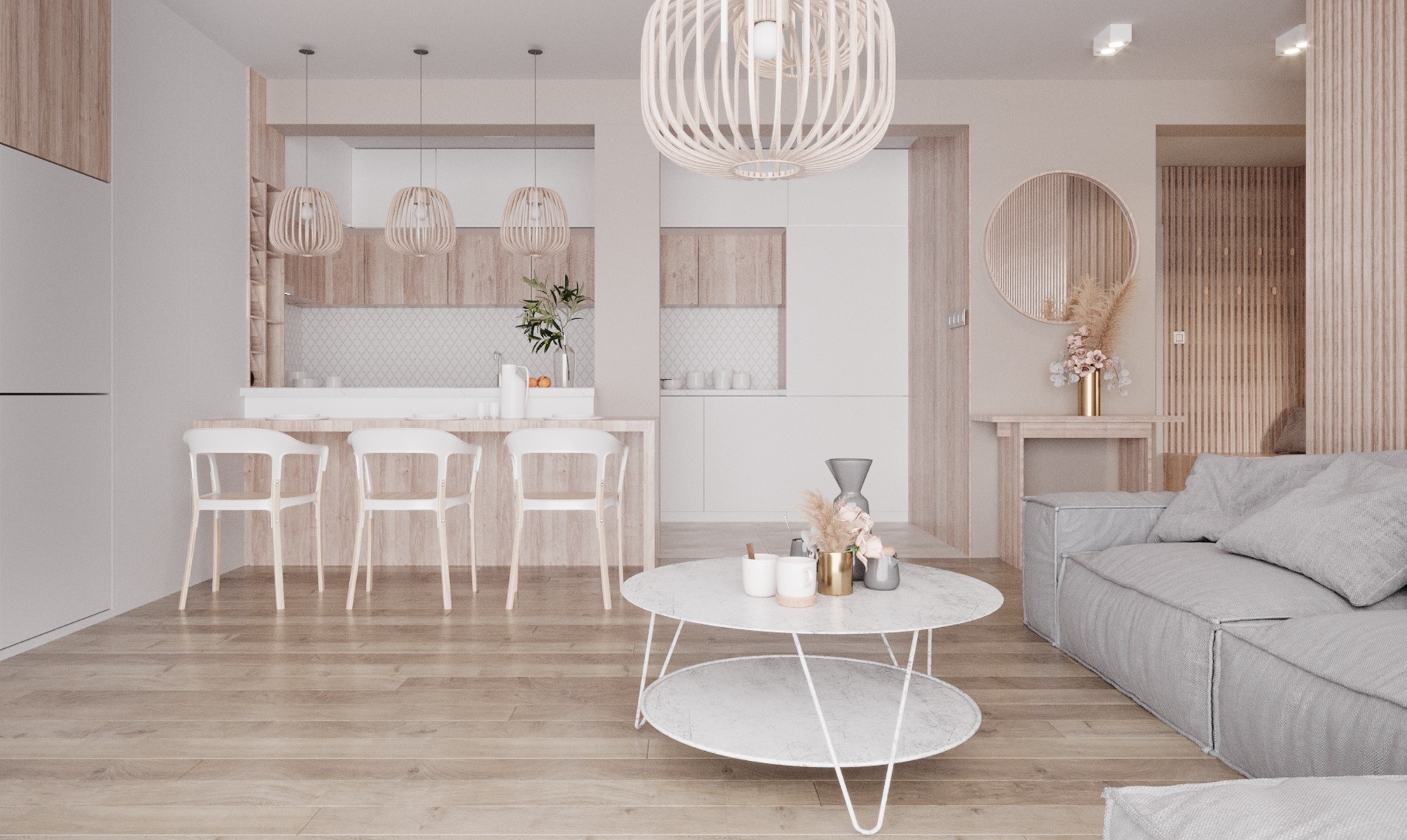 Jasne wnętrze salonu z aneksem kuchennym w stylu skandynawskim, z drewnianą podłogą i meblami w odcieniach beżu i bieli. Charakterystyczne ażurowe lampy wiszące nad wyspą kuchenną i okrągłe lustro...
