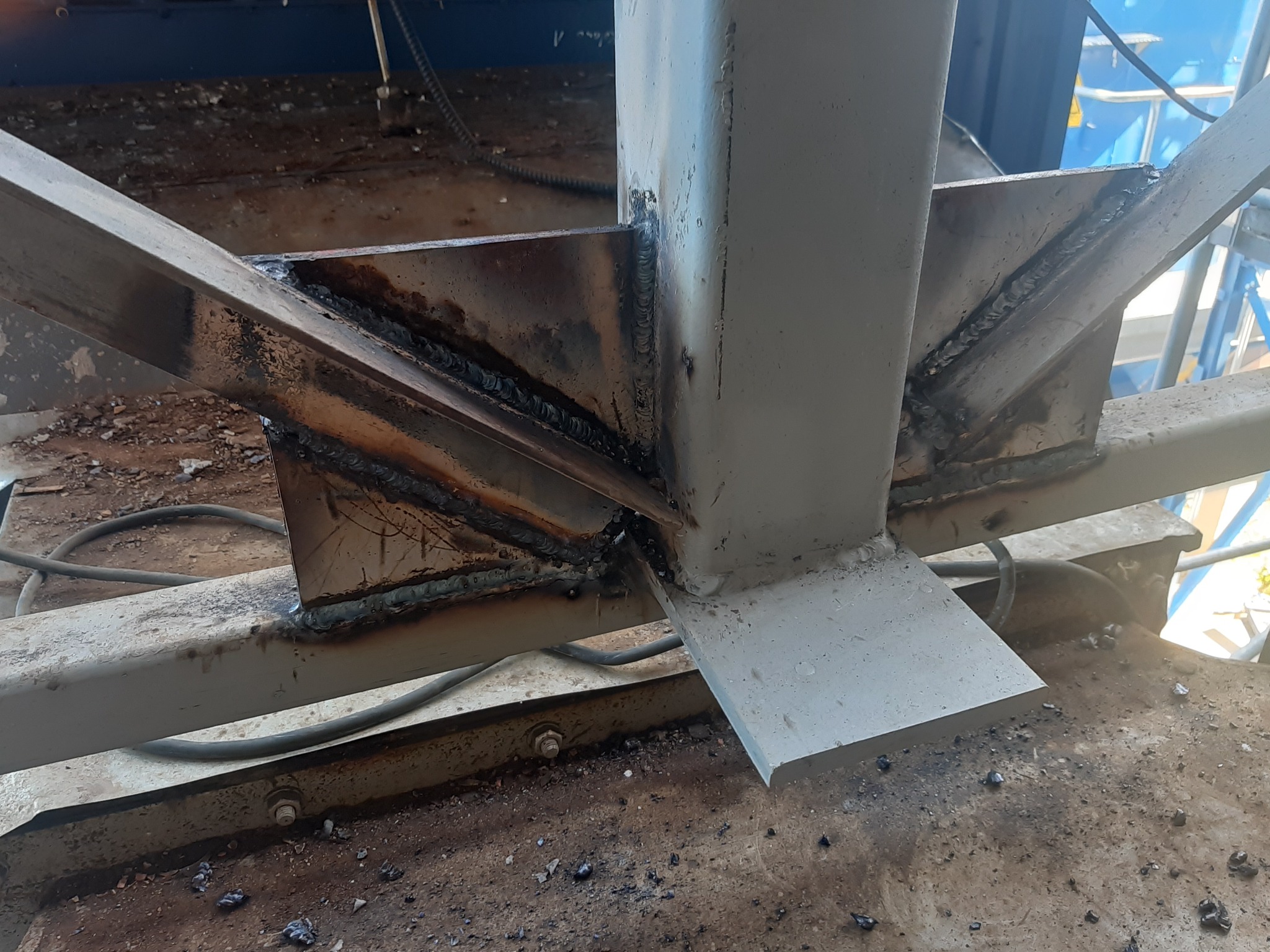 Fragment spawanej konstrukcji stalowej z widocznymi śladami spawania i niedoskonałościami na powierzchni.