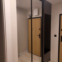 Adrian Świerczyński - Szafa wnękowa z lustrzanymi drzwiami przesuwnymi i siedziskiem w przedpokoju, odbicie drzwi wejściowych