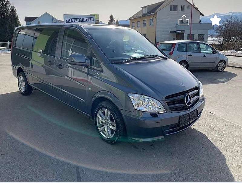 Szary Mercedes-Benz Vito, zaparkowany na zewnątrz, z tablicą 'Zu Vermieten' w tle, sugerujący wynajem.