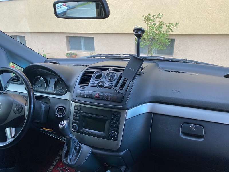 Wnętrze samochodu marki Mercedes-Benz Viano z widoczną deską rozdzielczą, kierownicą i dźwignią zmiany biegów. Na desce rozdzielczej zamontowany uchwyt na telefon.