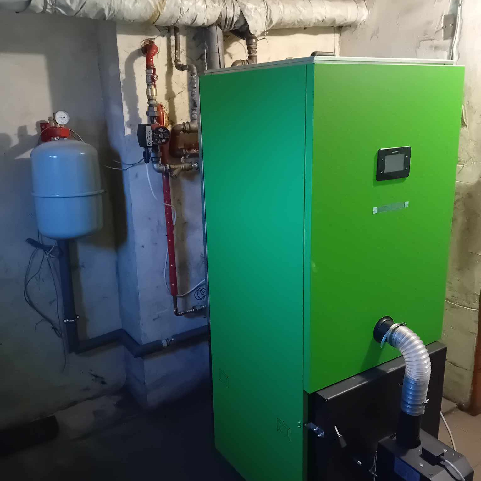 Nowoczesny, zielony piec CO w kotłowni. Widoczny zbiornik wyrównawczy i instalacja grzewcza. Ujęcie w piwnicy, oświetlenie sufitowe.