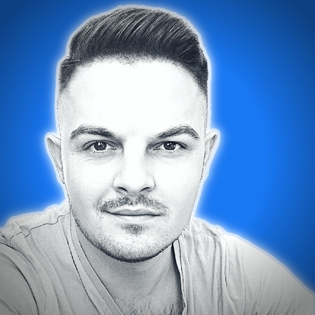 Portret młodego mężczyzny z krótką fryzurą i lekkim zarostem, na niebieskim tle z poświatą, w odcieniach szarości.