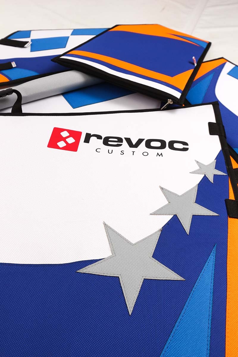 Zestaw kolorowych, niestandardowych toreb z logo 'revoc CUSTOM' i motywem gwiazd, prawdopodobnie do modelu zdalnie sterowanego samolotu, widoczne zamki błyskawiczne i uchwyty.