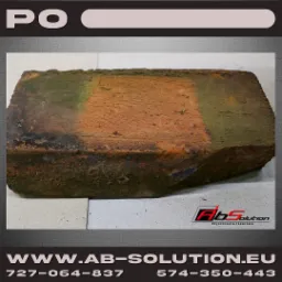 Cegła z fragmentem oczyszczonej powierzchni, widoczne zabrudzenia i ślady mchu, prezentacja efektu czyszczenia laserowego.